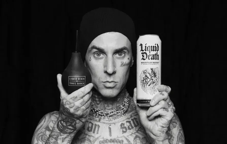 Blink 182 member Travis Barker holds an enema and can of Liquid Death.